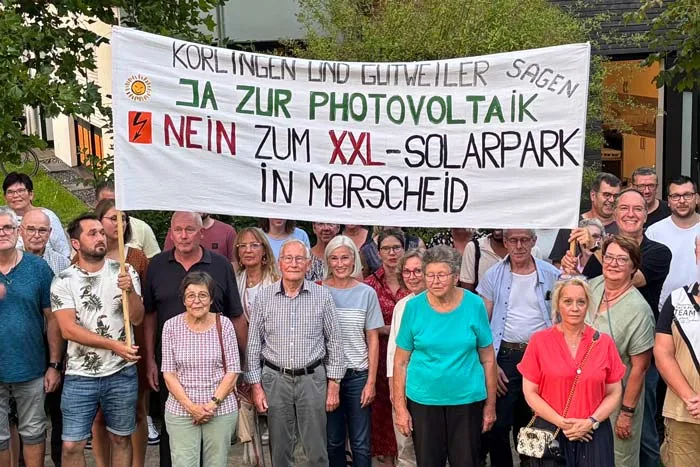 IG PV demonstriert mit großem Banner "KORLINGEN LIND GLITWEILER SAGEN JA ZUR PHOTOVOLTAIK NEIN ZUM XXL-SOLARPARK IN MORSCHEID"